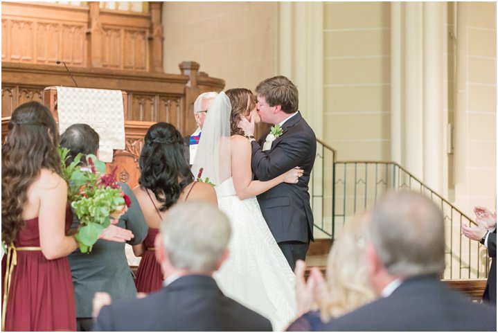 bride and groom first kiss in wedding ceremony at Dilworth United Methodist Church in Charlotte NC